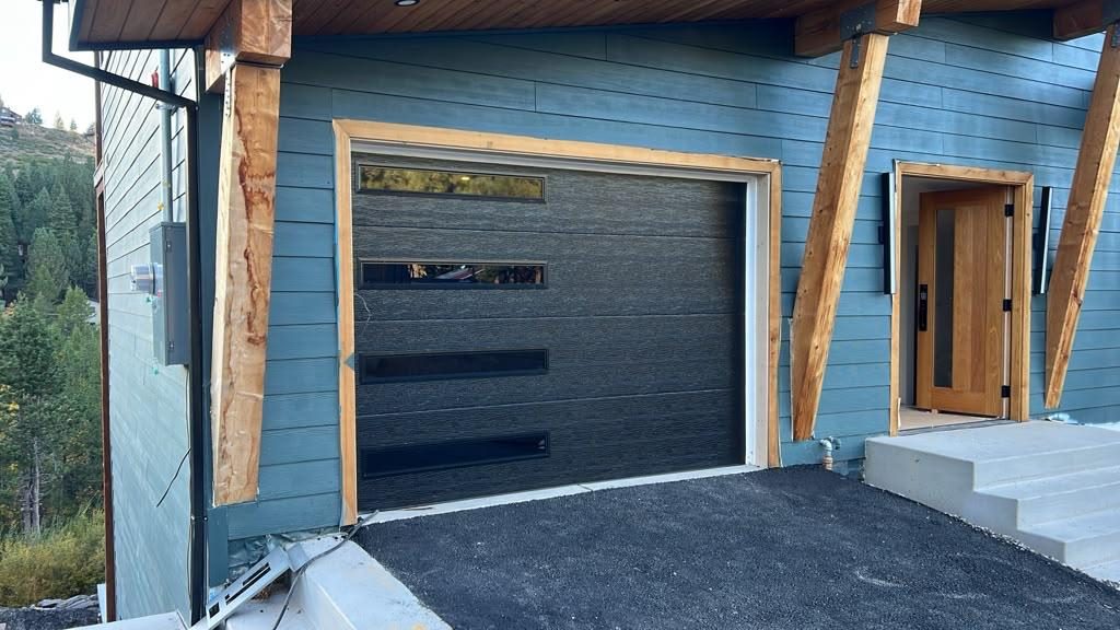 Black modern garage door with glass lites on a foothill home
