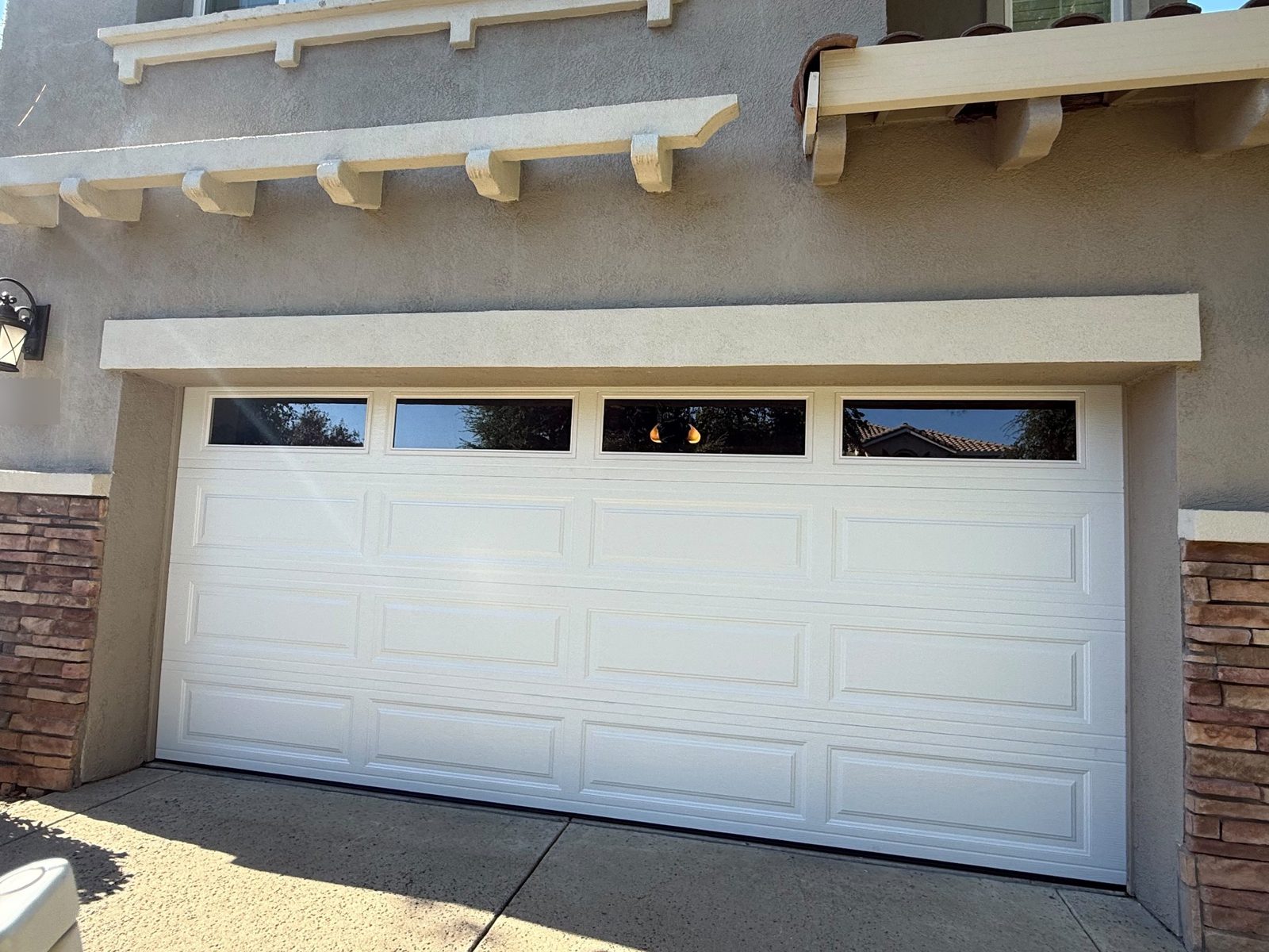 White raised-panel garage door with long window lites