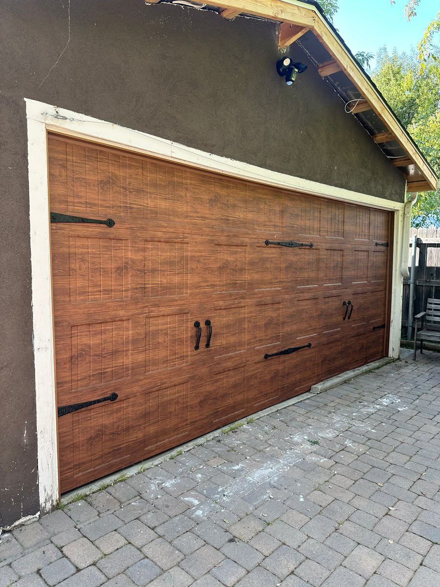 Woodgrain carriage house garage door with decorative black hardware