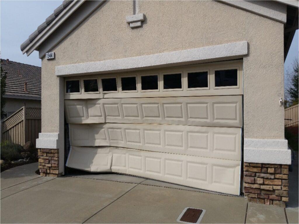 A garage door being repaired after a car accidentally backed into it.