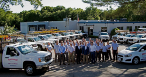 A team stands near trucks at a garage firm.