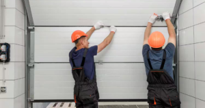 "Two workers installing a garage door."