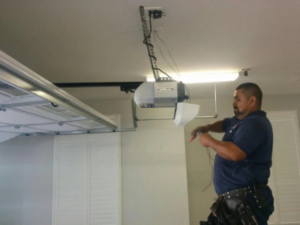 A technician installs a garage door opener.